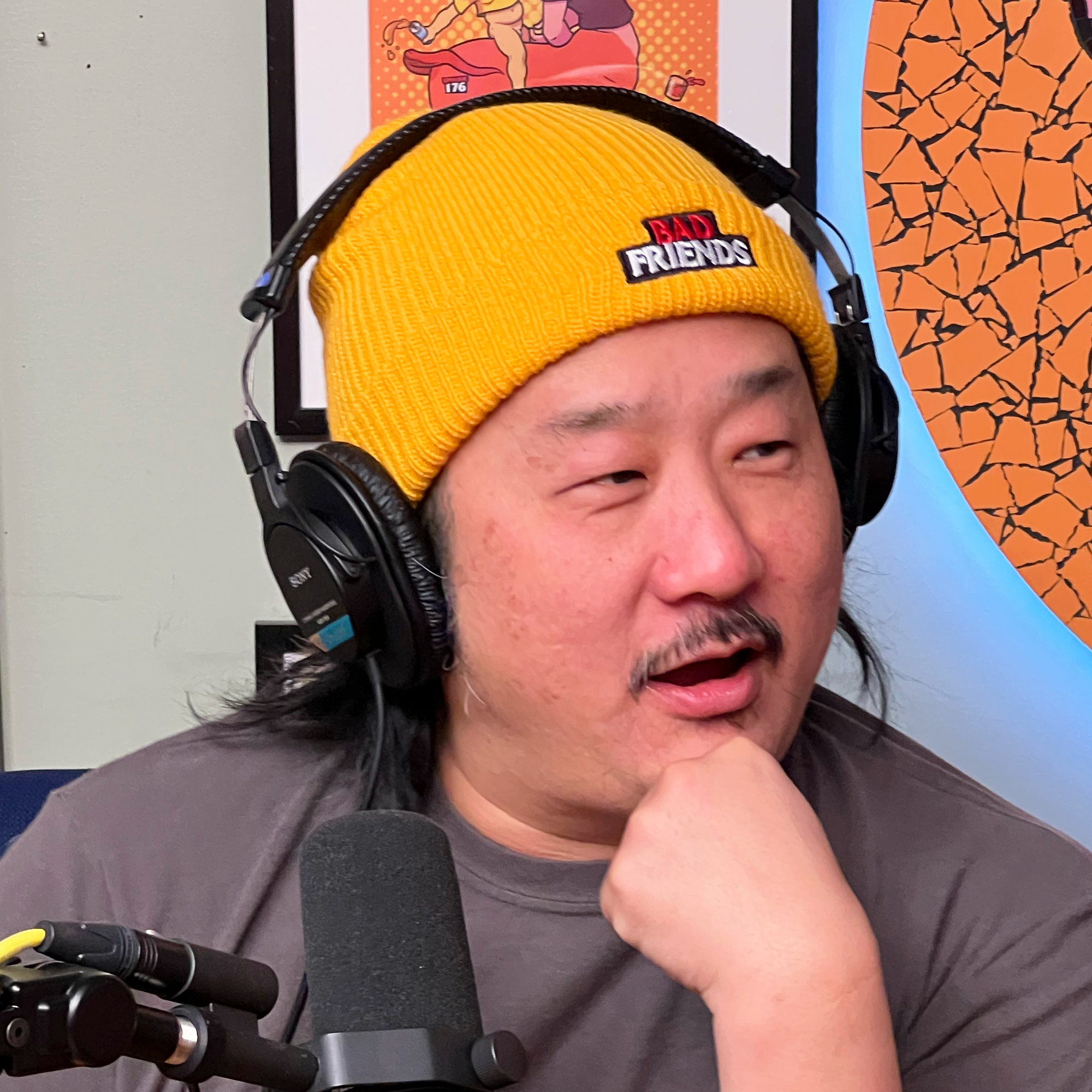 Bobby in his yellow bad friends embroidered beanie at his podcast chair